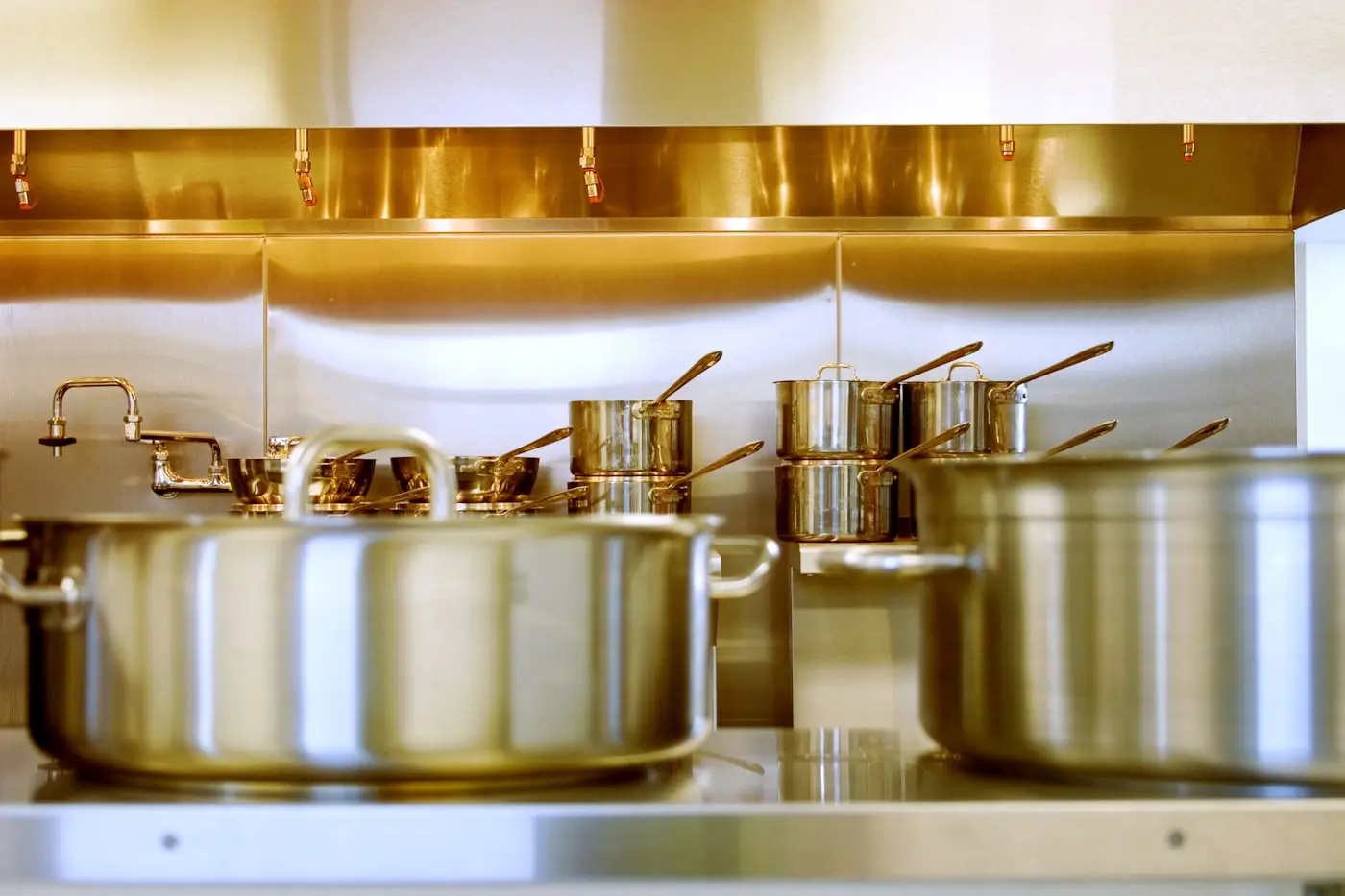 Stainless steel commercial canopy above a clean cooking line